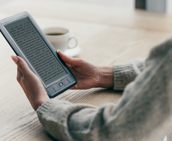 Young Asian woman reviewing graphs from multiple computers